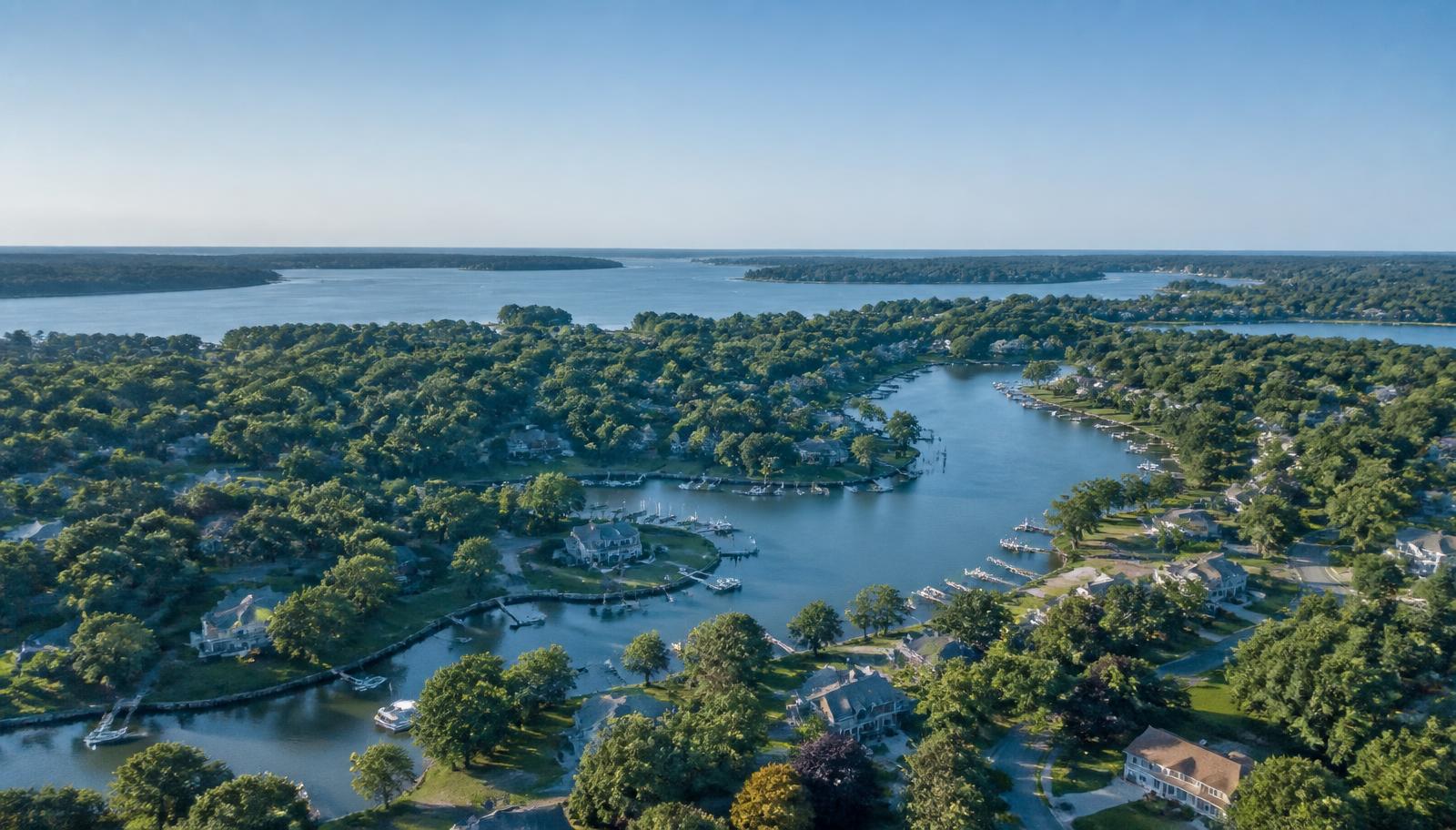 Aerial view of leafy Maryland neighborhoods beside a waterway